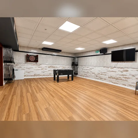 Sala de juegos con futbolín, diana y televisión en Espai Únic